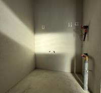 PREDAJ - NOVOSTAVBA - TESÁRSKE MLYŇANY - Prázdna miestnosť s betónovou podlahou a inštaláciami v rodinnom dome.