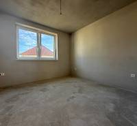 PREDAJ - NOVOSTAVBA - TESÁRSKE MLYŇANY - Miestnosť v rodinnom dome, steny bez dekorácií, vidno strechu susednej budovy.