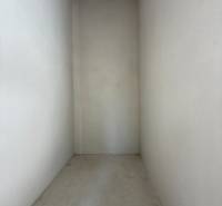 PREDAJ - NOVOSTAVBA - TESÁRSKE MLYŇANY - Úzky, prázdny interiér rodinného domu s betónovou podlahou a bielymi stenami.