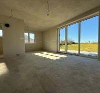 PREDAJ - NOVOSTAVBA - TESÁRSKE MLYŇANY - Priestranný interiér rodinného domu s veľkými oknami a výhľadom na záhradu.