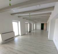 Prenajmeme kancelársky priestor, 40 m2, Levická ul., Vráble - Biela kancelária s podlahou s dreveným dekorom, dekoratívnymi trámami a svetlými stenami.