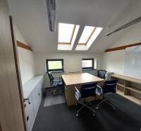 Ponúkame na prenájom kanceláriu, 15,54 m2, Levická ul., Vráble - Kancelária s podlahou s dreveným dekorom, strešnými oknami a stolmi so stoličkami.