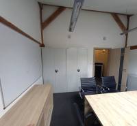 Ponúkame na prenájom kanceláriu, 15,54 m2, Levická ul., Vráble - Kancelárie so stolom, čiernymi stoličkami, skrinkami a bielou tabuľou.