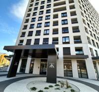 PRENÁJOM garáž Poprad, ul. Karpatská - Výšková budova na Karpatskej ulici v Poprade s moderným vstupom a oblými chodníkmi.