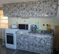 5-izbový rodinný dom na predaj v Hornom Ohaji, okr. NR, pozemok 1251m2 - Kuchyňa s obkladom, sporákom a krbom v rodinnom dome, podlaha s dreveným dekorom.