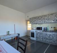 5-izbový rodinný dom na predaj v Hornom Ohaji, okr. NR, pozemok 1251m2 - Kuchyňa v rodinnom dome s pieckou a kuchynskou linkou, podlaha s dreveným dekorom.