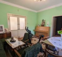 5-izbový rodinný dom na predaj v Hornom Ohaji, okr. NR, pozemok 1251m2 - Obývacia izba v rodinnom dome s nábytkom, cvičebným zariadením a zelenými stenami.