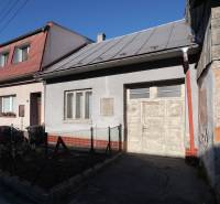 Menší rodinný dom len pár metrov od centra mesta Rajec - Rodinný dom na Kostolnej ulici v Rajci s autom vpredu a dreveným plotom.