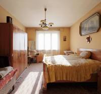 Menší rodinný dom len pár metrov od centra mesta Rajec - Spálňa v rodinnom dome s nábytkom, lusterom a obrazom na stene.