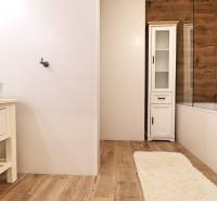 Na PRENÁJOM_ NÁDHERNÝ 3-izbový byt  - Kúpeľňa s bielymi obkladmi a podlahou s dreveným dekorom v 3-izbovom byte.