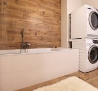 Na PRENÁJOM_ NÁDHERNÝ 3-izbový byt  - Kúpeľňa s vaňou, práčkou, sušičkou a stenou s dreveným dekorom v 3-izbovom byte.