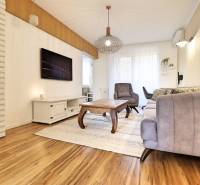 Na PRENÁJOM_ NÁDHERNÝ 3-izbový byt  - Obývacia izba s pohovkou a kreslom v 3-izbovom byte s podlahou s dreveným dekorom.