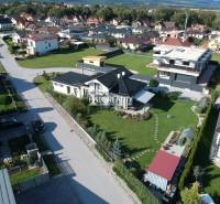 Predaj, rodinný dom Batizovce, + polyfunkčný objekt,... - Letecký pohľad na rodinný dom v Batizovciach so zelenou záhradou a okolitými domami.