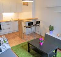 MODERNÝ 2i byt, NOVOSTAVBA, CENTRUM, Suché Mýto, Staré Mesto - Kuchyňa v 2-izbovom byte s bielym nábytkom, stolom a dekoráciami.