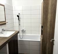 PREDAJ-  2 izbový byt neďaleko Nitry v obci Jarok - Kúpeľňa v 2-izbovom byte s vaňou, umývadlom a dreveným nábytkom.