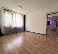 PREDAJ-  2 izbový byt neďaleko Nitry v obci Jarok - Priestranná izba s drevenou podlahou a závesmi v 2-izbovom byte.