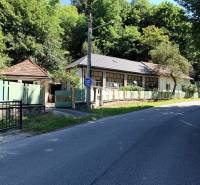 Na predaj  dom v obci Vyhne iba 400m od Vodného raja.  - Rodinný dom na ulici Vyhne obklopený zeleňou a plotmi, slnečný deň.