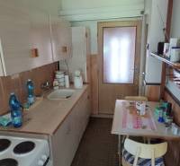 Na predaj  dom v obci Vyhne iba 400m od Vodného raja.  - Jednoduchá kuchyňa s dreveným nábytkom, drezom, sporákom a malým jedálenským stolom na ulici Vyhne v rodinnom dome.