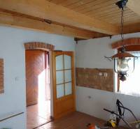 Štýlový rekreačný domček Levice - Interiér chaty s tehlovými ozdobami, podlahou s dreveným dekorom a visiacim svietidlom.