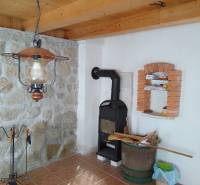 Štýlový rekreačný domček Levice - Chata s kachľami, kamennou stenou a podlahou s dreveným dekorom.