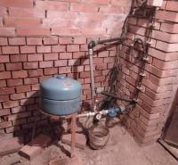 Štýlový rekreačný domček Levice - Tehlová stena a vodárenské zariadenie v interiéri chaty.