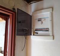 Štýlový rekreačný domček Levice - Otvorená rozvodná skriňa s ističmi v Chate, vedľa otvorených dverí.