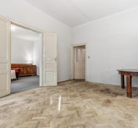 3- izb. byt o výmere 105m2 v historickom centre. - Interiér 3-izbového bytu so starším nábytkom a podlahou s dreveným dekorom.