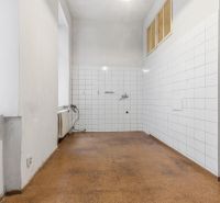 3- izb. byt o výmere 105m2 v historickom centre. - Prázdna miestnosť v 3-izbovom byte s bielymi dlaždicami a podlahou hnedého odtieňa.