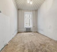 3- izb. byt o výmere 105m2 v historickom centre. - Prázdna miestnosť s podlahou s dreveným dekorom v 3-izbovom byte, jednoduchý luster.
