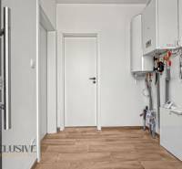IDEÁLNY 1 IZBOVÝ BYT | VEĽKÉ RIPŇANY | TOPOĽČANY - Vstupná chodba v 1-izbovom byte s bielymi stenami a podlahou s dreveným dekorom.