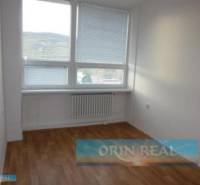 PRENÁJOM KANCELÁRSKÝCH PRIESTOROV NA RAČIANSKEJ ULICI - Izba s drevenou podlahou a veľkým oknom, ideálny priestor na kancelárie na ulici Račianska.