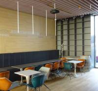 PRENÁJOM NEB.PRIESTORU V POLYFUNKČNOM DOME V CENTRE PEZINKA - Interiér bistra na ulici Moyzesova, s farebnými stoličkami a dekoratívnym drevom. Obchodné priestory.