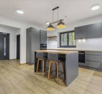 PREDAJ 8 IZB.REKREAČNEJ CHATY - VILY V MODRE HARMÓNII - Moderná kuchyňa s ostrovčekom, drevenou podlahou a závesnými svietidlami, na ulici Piesok.