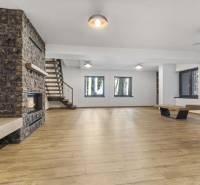 PREDAJ 8 IZB.REKREAČNEJ CHATY - VILY V MODRE HARMÓNII - Na obrázku je priestranná miestnosť s krbom, drevenými schodmi a veľkými oknami.