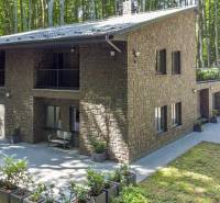 PREDAJ 8 IZB.REKREAČNEJ CHATY - VILY V MODRE HARMÓNII - Dom s kamennou fasádou a terasou pri lese, blízko ulice Piesok a chaty.