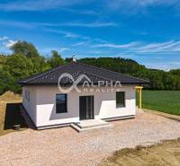 EXKLUZÍVNE: Novostavba 4i bungalov, obec Harichovce, okres Sp. Nová Ve - Rodinný dom v Harichovciach s bielou fasádou a tmavou strechou v prírodnom prostredí.