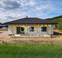 EXKLUZÍVNE: Novostavba 4i bungalov, obec Harichovce, okres Sp. Nová Ve - Rodinný dom v Harichovciach s terasou a záhradou, obklopený prírodou a modrou oblohou.