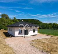 EXKLUZÍVNE: Novostavba 4i bungalov, obec Harichovce, okres Sp. Nová Ve - Rodinný dom v Harichovciach, obklopený zeleňou, s veľkým dvorom a modrou oblohou.