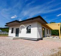 EXKLUZÍVNE: Novostavba 4i bungalov, obec Harichovce, okres Sp. Nová Ve - Rodinný dom v Harichovciach so šikmou strechou a drevenou pergolou na pozadí modrej oblohy.