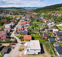 Exkluzívne na predaj, rodinný dom, obec Harichovce, okres Spišská Nová - Letecký pohľad na zástavbu rodinných domov v Harichovciach obklopenú zeleňou a kopcami.