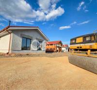 Exkluzívne novostavba rodinný dom - bungalov, Spišské Podhradie - Rodinný dom v Spišskom Podhradí so strojom na úpravu terénu za slnečného počasia.