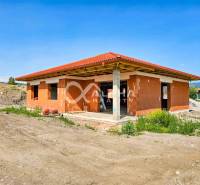 Exkluzívne novostavba rodinný dom - bungalov, Spišské Podhradie - Rodinný dom v Spišskom Podhradí vo fáze výstavby s červenou strechou a tehlovými múrmi.