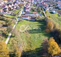EXKLUZÍVNE stavebné pozemky, Spišské Podhradie - Letecký pohľad na pozemky určené na bývanie v Spišskom Podhradí obklopené domami a zeleňou.