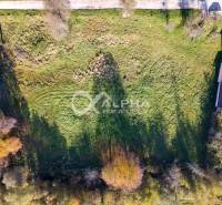 EXKLUZÍVNE stavebné pozemky, Spišské Podhradie - Letecký pohľad na pozemky určené na bývanie v Spišskom Podhradí, obklopené zeleňou a budovami.