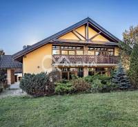 Exkluzívny rodinný dom, Veľká Lomnica, okres Kežmarok - Rodinný dom vo Veľkej Lomnici s drevenými prvkami, obklopený zeleňou a trávnikom.