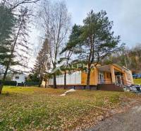 Budova s pozemkom, obec Helcmanovce, okres Gelnica - Budova v Helcmanovciach obklopená stromami, so schodiskom vedúcim k vchodu.