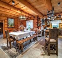 Zrubový rodinný dom, Veľká Lomnica - Rustikálna jedáleň s drevenými trámami a tradičným nábytkom v rodinnom dome.