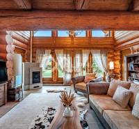 Zrubový rodinný dom, Veľká Lomnica - Obývacia izba v Rodinnom dome s drevenými trámami, krbom a pohodlným sedením.