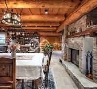 Zrubový rodinný dom, Veľká Lomnica - Útulný interiér rodinného domu s krbom, dreveným dekorom a rustikálnym zariadením kuchyne.