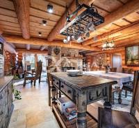 Zrubový rodinný dom, Veľká Lomnica - Drevený interiér s jedálenským stolom a dekoráciami v rodinnom dome.